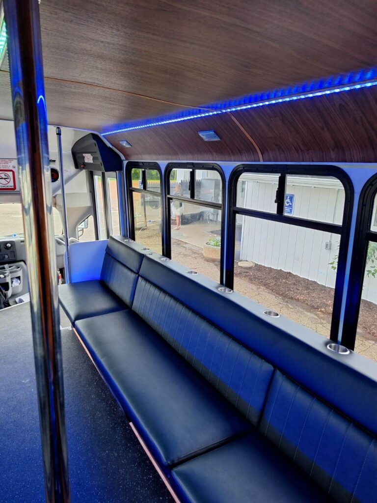 Empty bus interior with black seats, blue lights, perfect for a Wisconsin wedding shuttle ride.