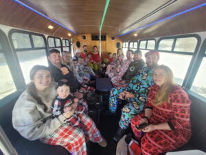 Large group in pajamas smiling on a bus—perfect for a Wisconsin bachelorette party adventure!.