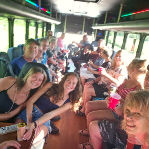 Friends enjoy drinks and laughs on an Xtreme Party Bus Service during a lively bachelor party ride.