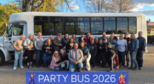 A group poses by a white bus with a Party Bus 2026 sign from Xtreme Party Bus Service.