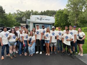 A bachelor party group in matching shirts poses by a white Xtreme Party Bus Service bus outdoors.