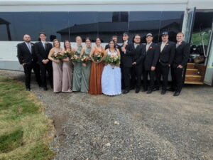 Wedding party posing outside, celebrating with an Xtreme Party Bus Service before the ceremony.