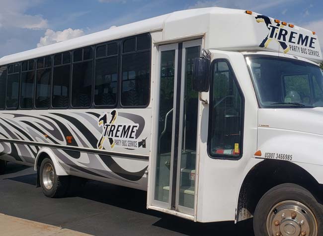 White limo bus with zebra stripes and Xtreme Party Bus Service logo, perfect for a bachelor party.