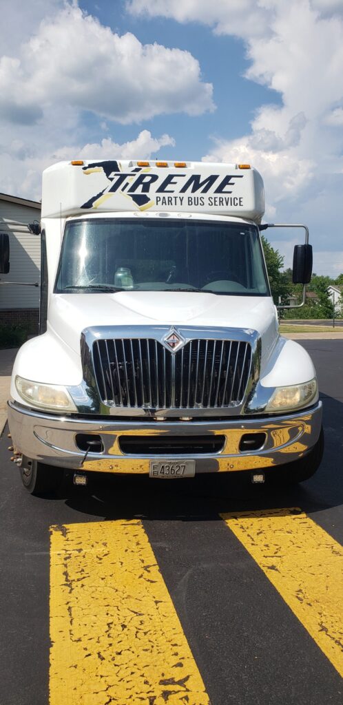 White limo bus labeled Xtreme Party Bus Service serves as a stylish Wisconsin wedding shuttle.